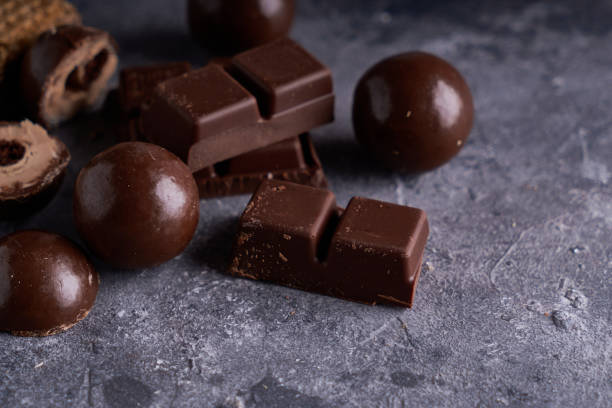 istock broken black and white chocolate. Pieces of chocolates on a gray stone table 1194645239