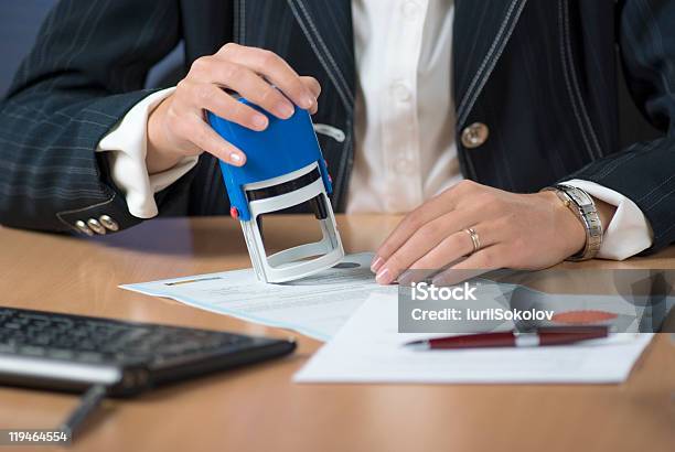 A Businesswoman Notarizing A Document With A Stamp Stock Photo - Download Image Now - Shorthand, Rubber Stamp, Document