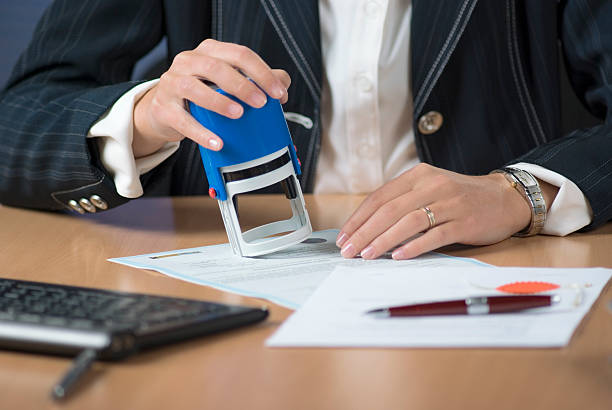 a businesswoman notarizing a document with a stamp - steno stok fotoğraflar ve resimler