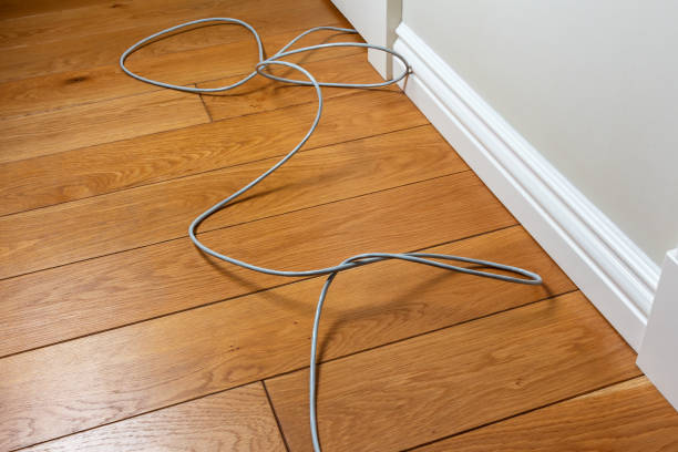 internet cable is lying on the floor of the room and interferes with the passage - fiber optic computer network cable network server imagens e fotografias de stock