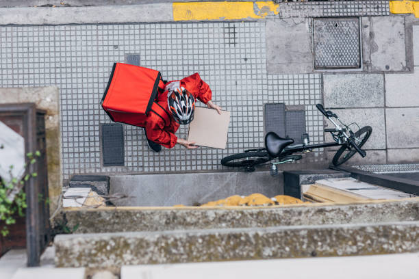 Man delivering pizza in city One man, delivery guy in city, delivering pizza in city, holding pizza box. food delivery stock pictures, royalty-free photos & images