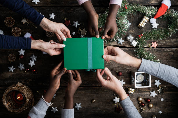 Family of four holding green holiday gift box stock photo