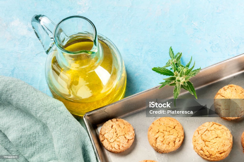 Cannabis butter cookies with marijuana buds and cannaoil, infused olive oil, homemade healthy biscuits in a baking tray with copy space Cannabidiol Stock Photo