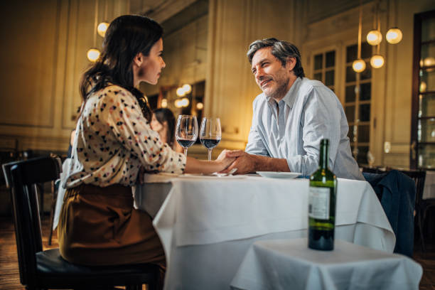 istock Modern couple holding hands on a date in restaurant 1194654404