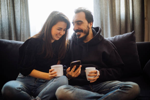 istock Couple looking at mobile phone at home 1194655329