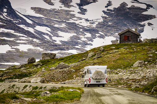 Mountains landscape and camper car on national tourist scenic route Gamle Strynefjellsvegen. Travel in motor home and adventure.