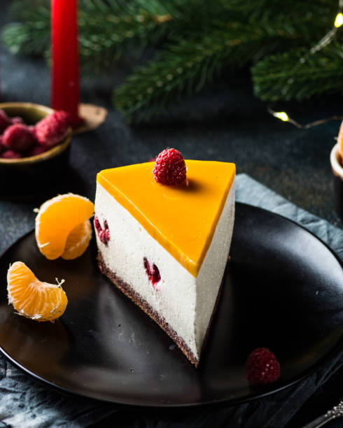 creamy mascarpone cheese cake. new york cheesecake. christmas dessert. healthy food. creative atmospheric decoration. candles. mango, raspberry cake. piece of cake. new year dessert - raspberry table wood autumn imagens e fotografias de stock