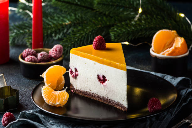 creamy mascarpone cheese cake. new york cheesecake. christmas dessert. healthy food. creative atmospheric decoration. candles. mango, raspberry cake. piece of cake. new year dessert - raspberry table wood autumn imagens e fotografias de stock