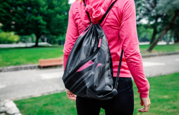Unrecognizable athlete woman with backpack going to the gym outdoors