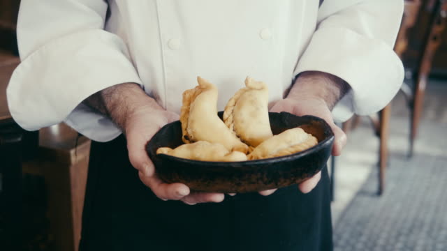 Close-up of chef holding empanadas in Argentinian restaurant