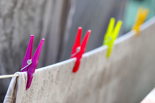 Colourfull laundry clips hold drying bed linen