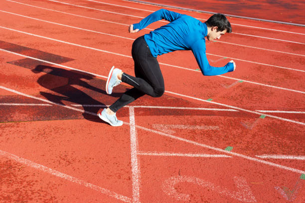 istock Runner starting his sprint on running track in a stadium. 1194661133