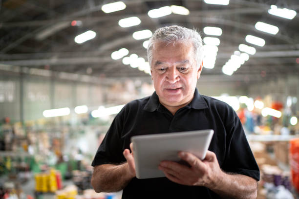 istock Focused manager using digital tablet in a factory 1194661331
