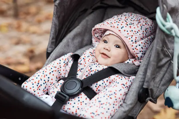 Cropped shot of an adorable baby girl sitting inside her pram outdoors