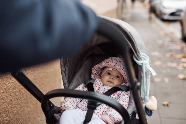 She's getting chauffeured around the city Cropped shot of an adorable baby girl getting pushed inside her pram by her father outdoors baby stroller winter stock pictures, royalty-free photos & images