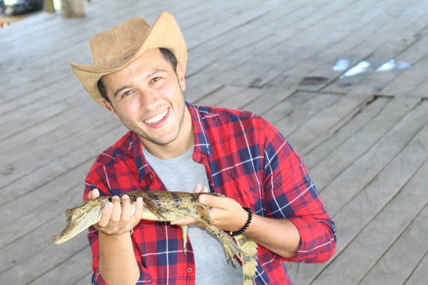 istock Zookeeper enjoying work with a baby caiman 1194666738