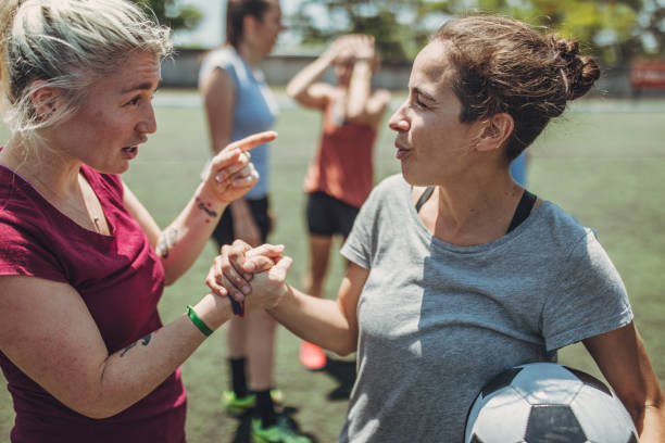 Women soccer players shaking hands Group of women, female soccer players together outdoors on soccer field, two women shaking hands. football player girlfriend stock pictures, royalty-free photos & images