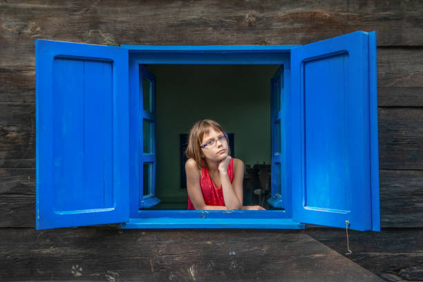 istock Girl looking out the window 1194668557