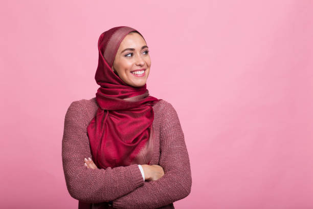 Religious girl enjoying in photo studio Young woman standing in front pink background arab woman stock pictures, royalty-free photos & images