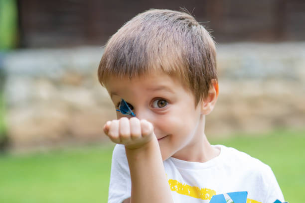 istock Little Boy Making Funny Face  And Looking Dragonfly 1194669697