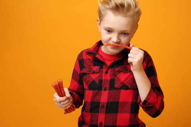 istock Child boy eats dry sausages. 1194669700