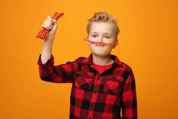 istock Child boy eats dry sausages. 1194669712