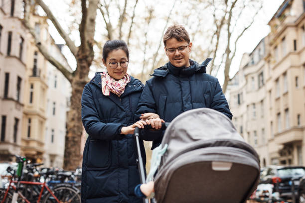 Family is a haven in a world full of chaos Shot of a happy young couple pushing their infant daughter in her pram on a day spent together outdoors baby stroller winter stock pictures, royalty-free photos & images