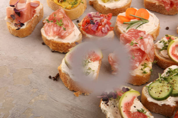 istock Assorted bruschetta with various toppings. Appetizing bruschetta or brie crostini. Variety of small sandwiches. Mix bruschetta on table 1194672780