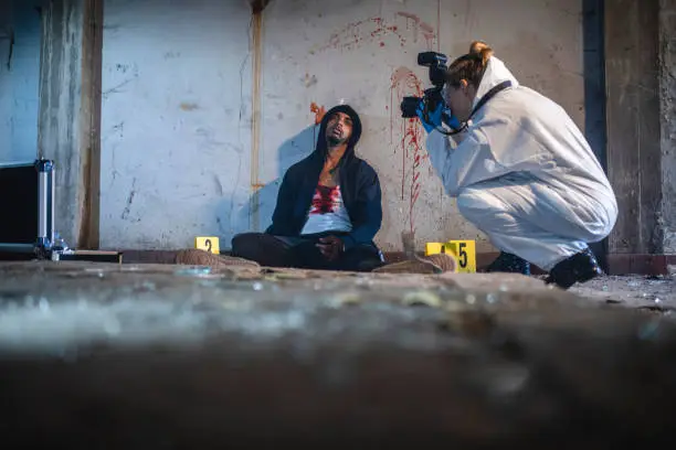 Photo of Investigator Photographing Victim at Crime Scene