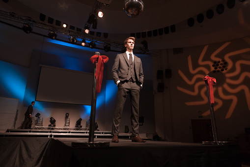 confident male model showing off business suit during fashion show