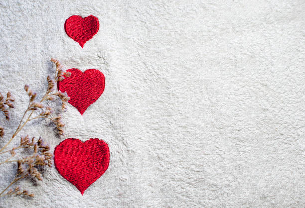 Three embroidered hearts on a white towel. Flowers Place for text. Copy space. Valentine's Day