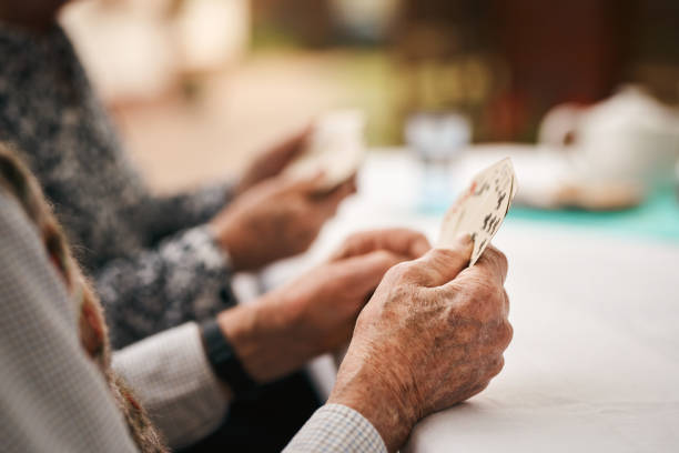 Bridge keeps us alert in our old age Cropped shot of an unrecognizable man sitting and holding cards during a game of bridge outdoors bridge hand stock pictures, royalty-free photos & images