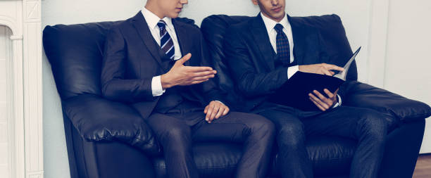 istock two businessmen discussing documents sitting on a sofa in the meeting room 1194675787