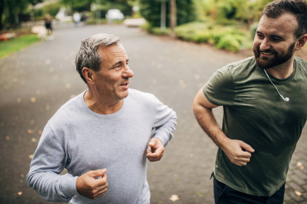 istock Father and son jogging in park 1194677075