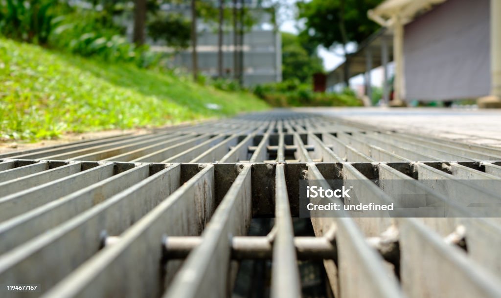 close up view of a sidewalk drainage gate close up of a sidewalk drainage gate Sewage Treatment Plant Stock Photo