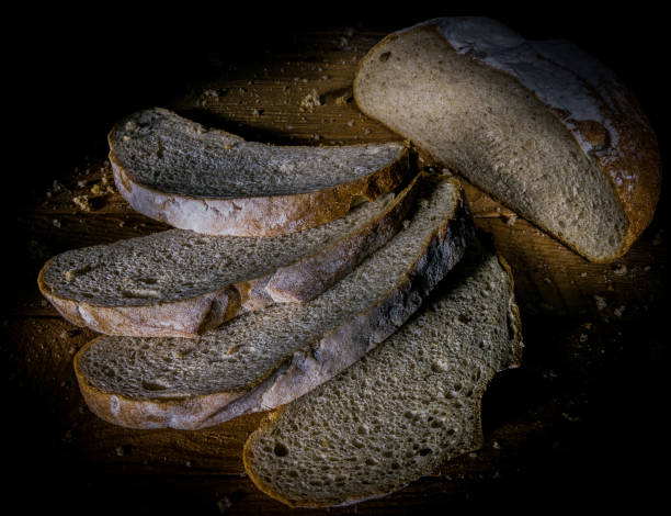 istock Rye bread loaf cut into four slices close - up view from above. 1194677290