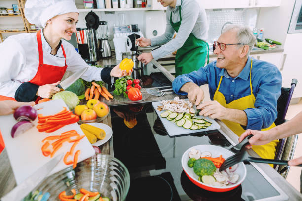 istock Chef and group cutting vegetables and cooking together 1194678010