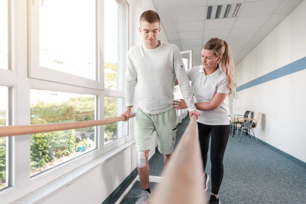 istock Therapist helping young man learning to walk again in rehabilitation 1194678120