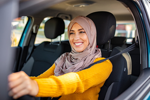 Portrait of muslim young woman driving her car. Arab women driving car. Middle Eastern Woman Driving a Car, Looking Forward. Get driving license concept