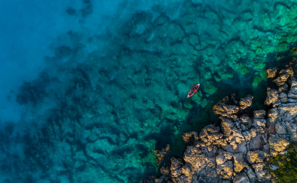 istock Woman kayaking clear turquoise sea 1194680844