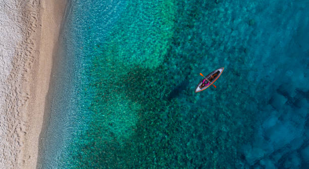 istock Woman kayaking clear turquoise sea 1194682063