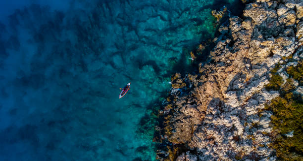 istock Woman kayaking clear turquoise sea 1194682111