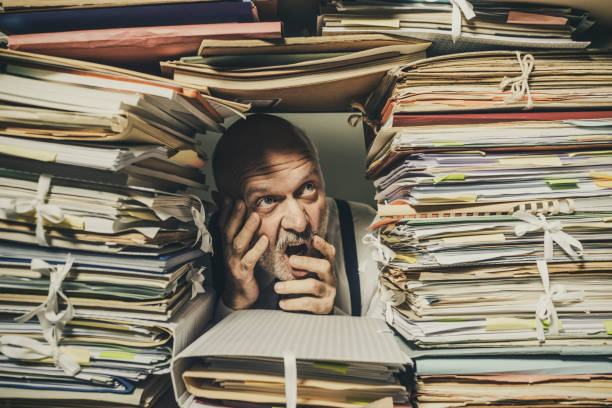istock Panicked businessman overwhelmed with paperwork 1194682520