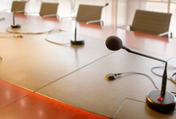 istock microphone on a wooden table and empty chairs in a boardroom 1194683066