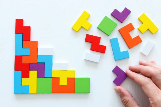 istock man's hand holding a square tangram puzzle, over wooden table 1194685087
