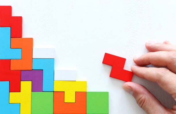 istock man's hand holding a square tangram puzzle, over wooden table 1194685089
