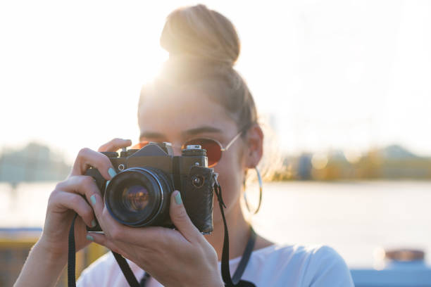istock young woman photographer using a camera in bright daylight 1194685680