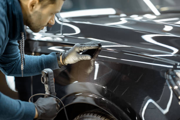 operaio che esamina il corpo del veicolo per graffi - car examining mechanic auto mechanic foto e immagini stock