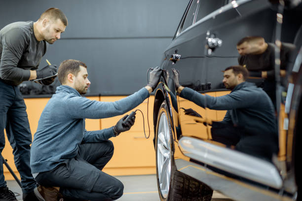 ouvriers examinant le corps de véhicule pour des rayures - carrosserie photos et images de collection