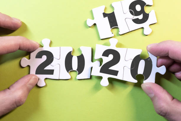 istock new year concept with hands replacing puzzle pieces with 2019 to 2020 1194687828